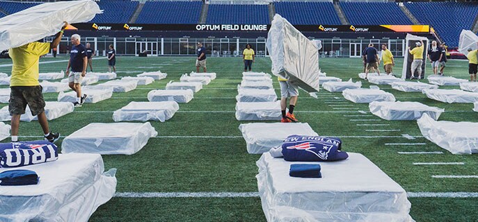 Volunteers set up the 200 beds on the field at Gillette Stadium.