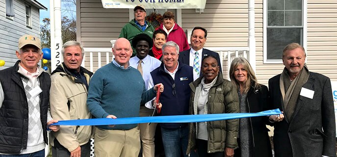Representatives from Bob's Discount Furniture and the New York Giants help cut the ribbon on the new Rights of Passage II home in Asbury Park, New Jersey.