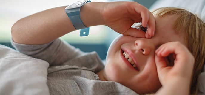 Children's hospital patient smiling and putting hands over her eyes